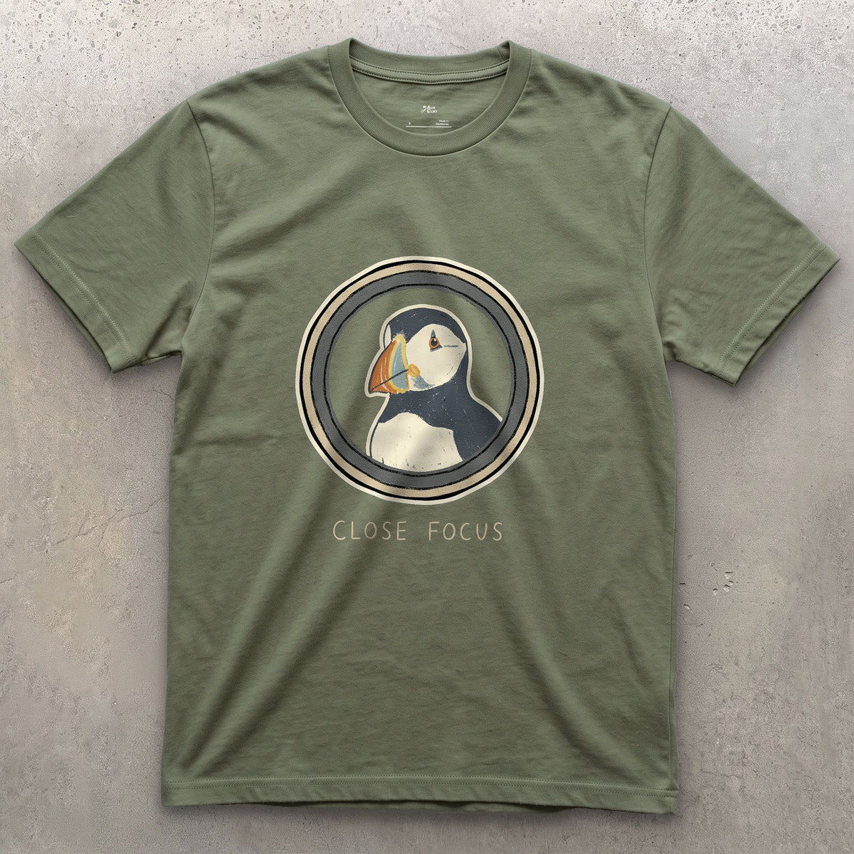 Close Focus on a Puffin design on a Military Green Gildan Softstyle t-shirt