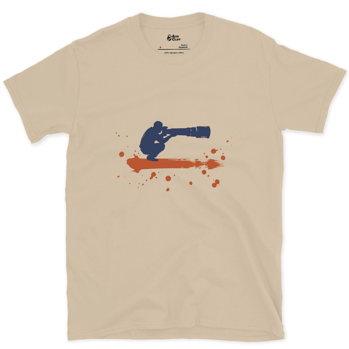 Crouched Behind the Lens design on a Sand Gildan Softstyle t-shirt