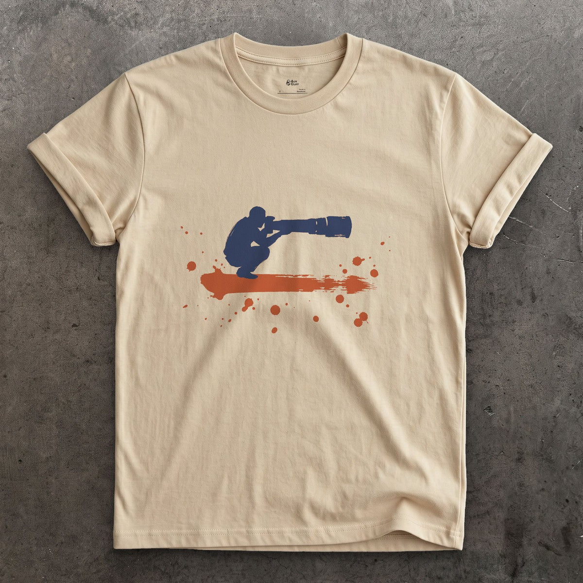 Crouched Behind the Lens design on a Sand Gildan Softstyle t-shirt