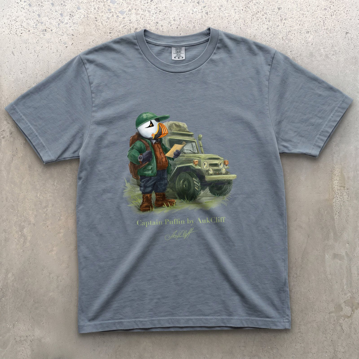 Captain Puffin Overland Explorer on a Blue Jean Comfort Colors t-shirt