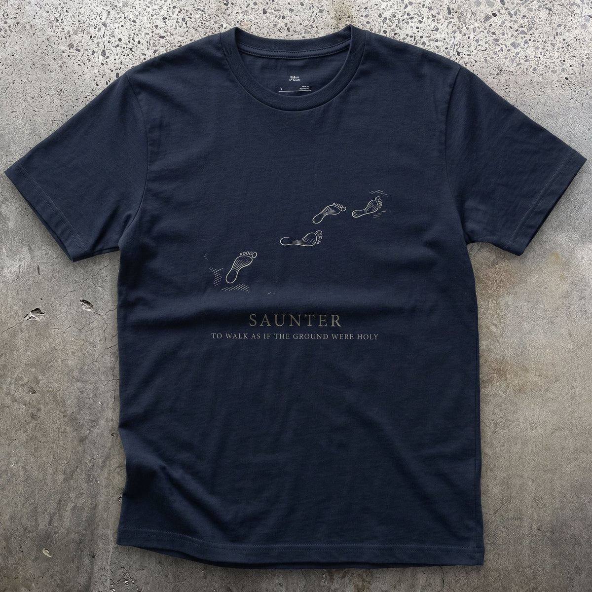 Saunter, to Walk As If the Ground Were Holy design on a Navy Gildan Softstyle t-shirt