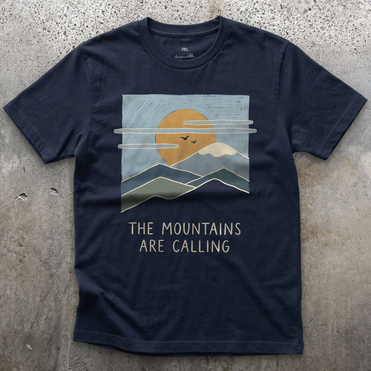 The Mountains Are Calling Over a Range at Sunset design on a Navy Gildan Softstyle t-shirt