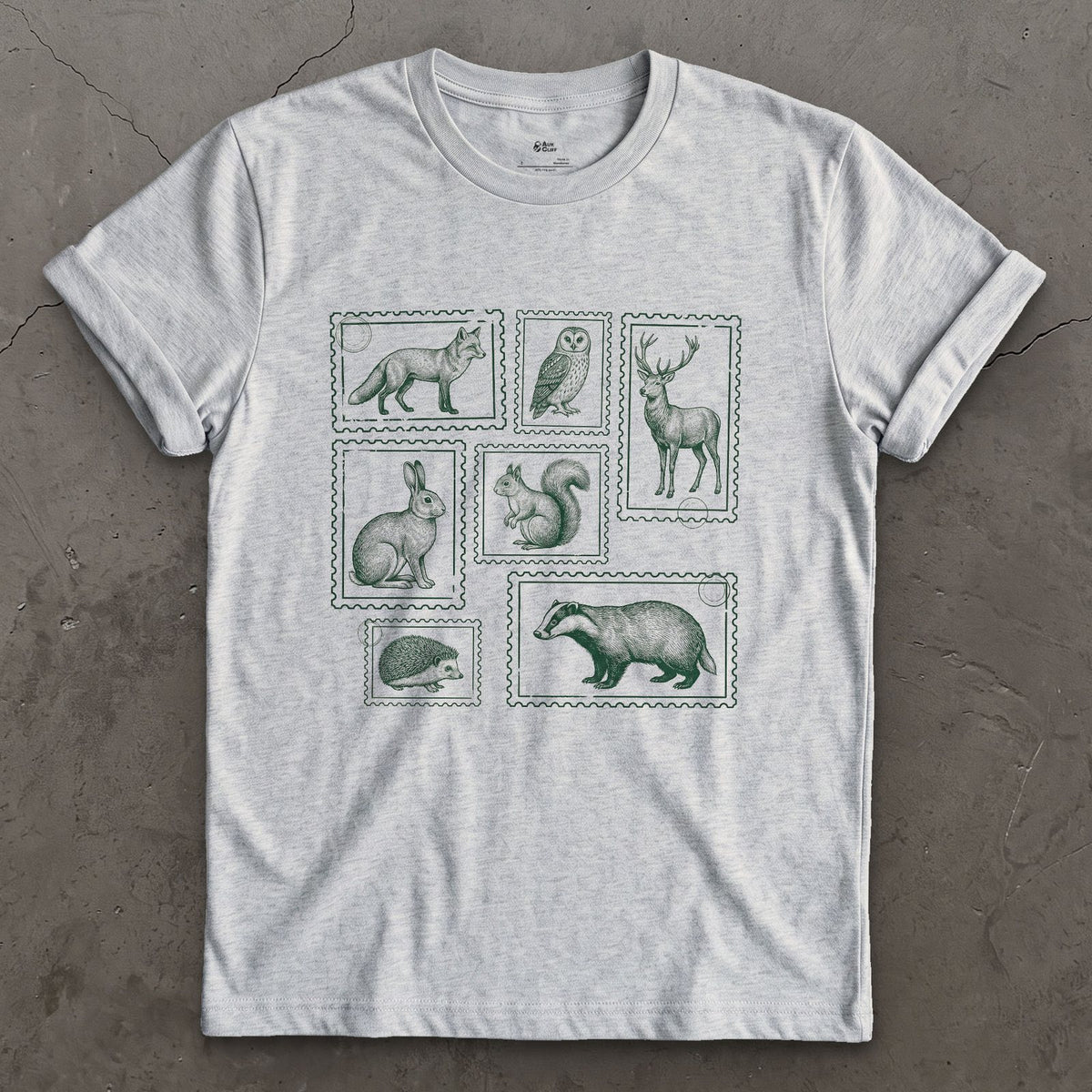 The Whole Woodland Framed Like Stamps design on a Sport Grey Gildan Softstyle t-shirt
