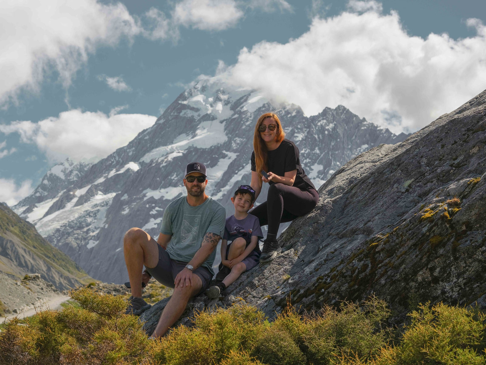 Stephen, Emma and their son on a rock below Aoraki