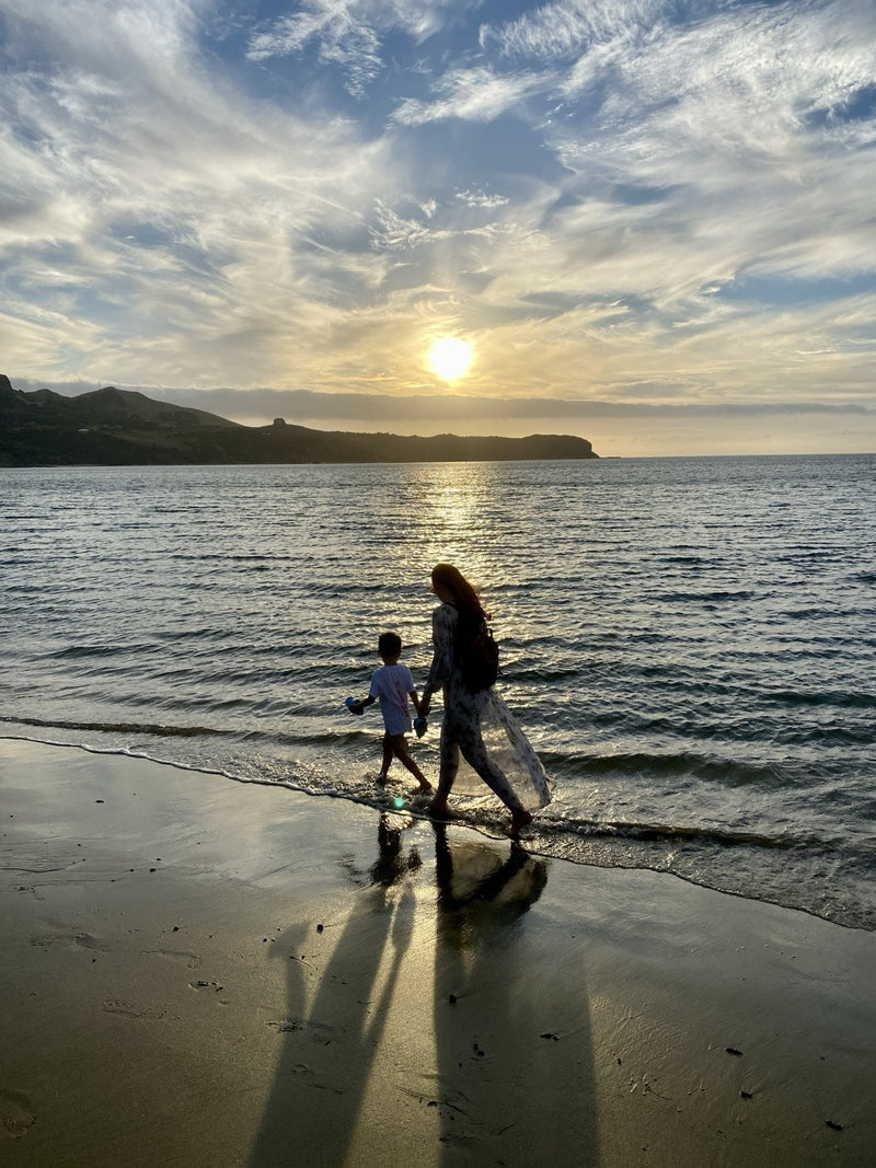 Walking the shoreline at sunset, the sun low over the water
