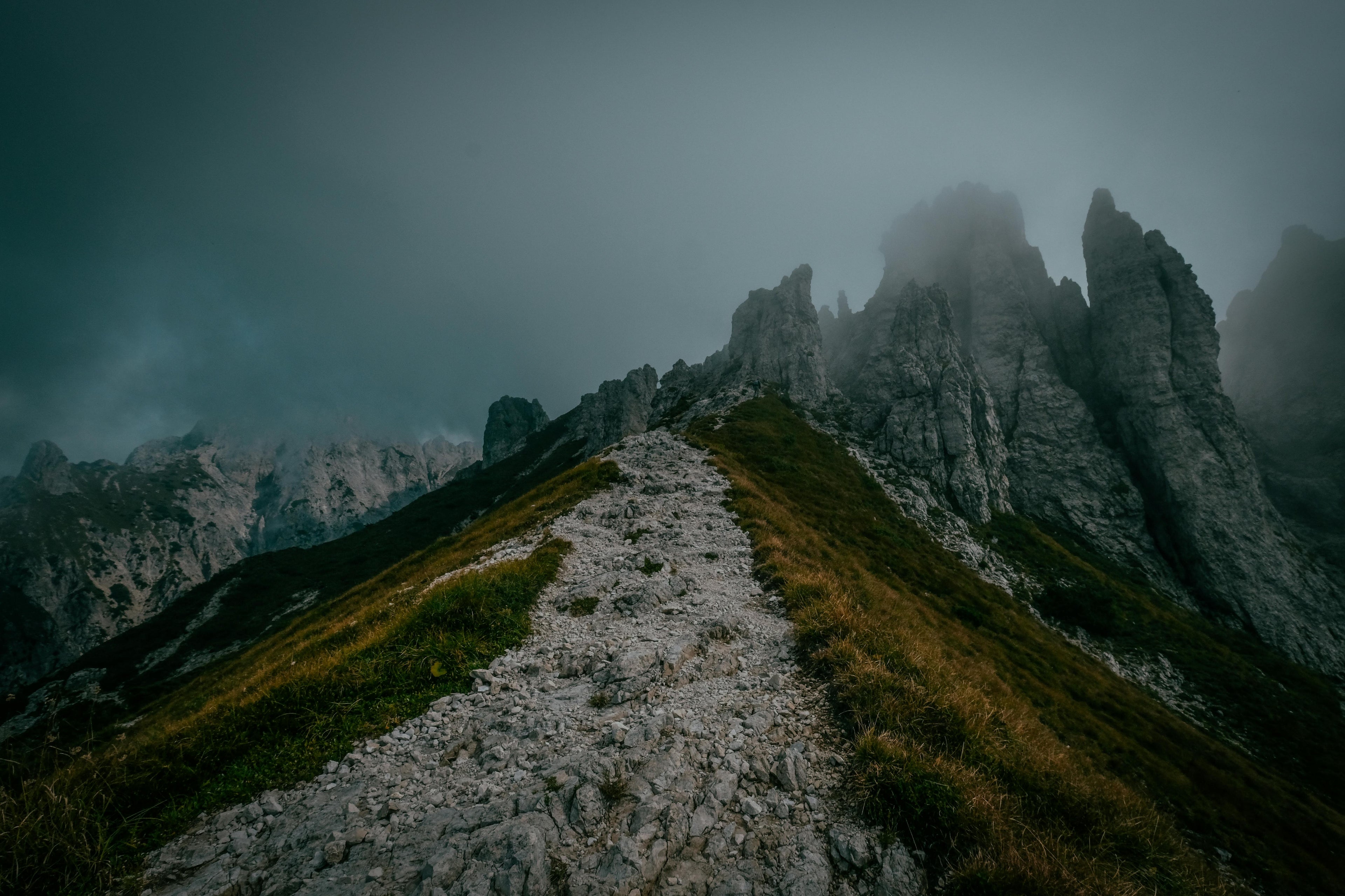 Capture of a misty mountain peak in Mandello del Lario, Italy, showcasing a dramatic, rugged landscape.
