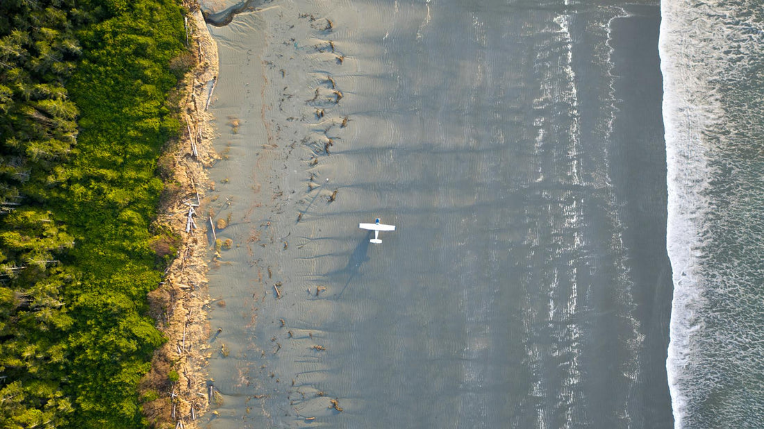 Aerial view of a small bush plane on the wet sand of a remote BC beach