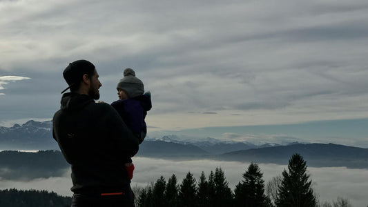 Father and child hiking in the mountains at golden hour
