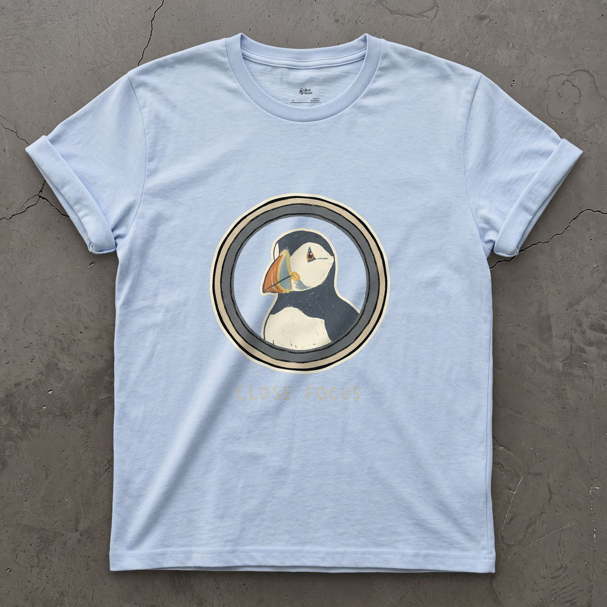Close Focus on a Puffin design on a Light Blue Gildan Softstyle t-shirt