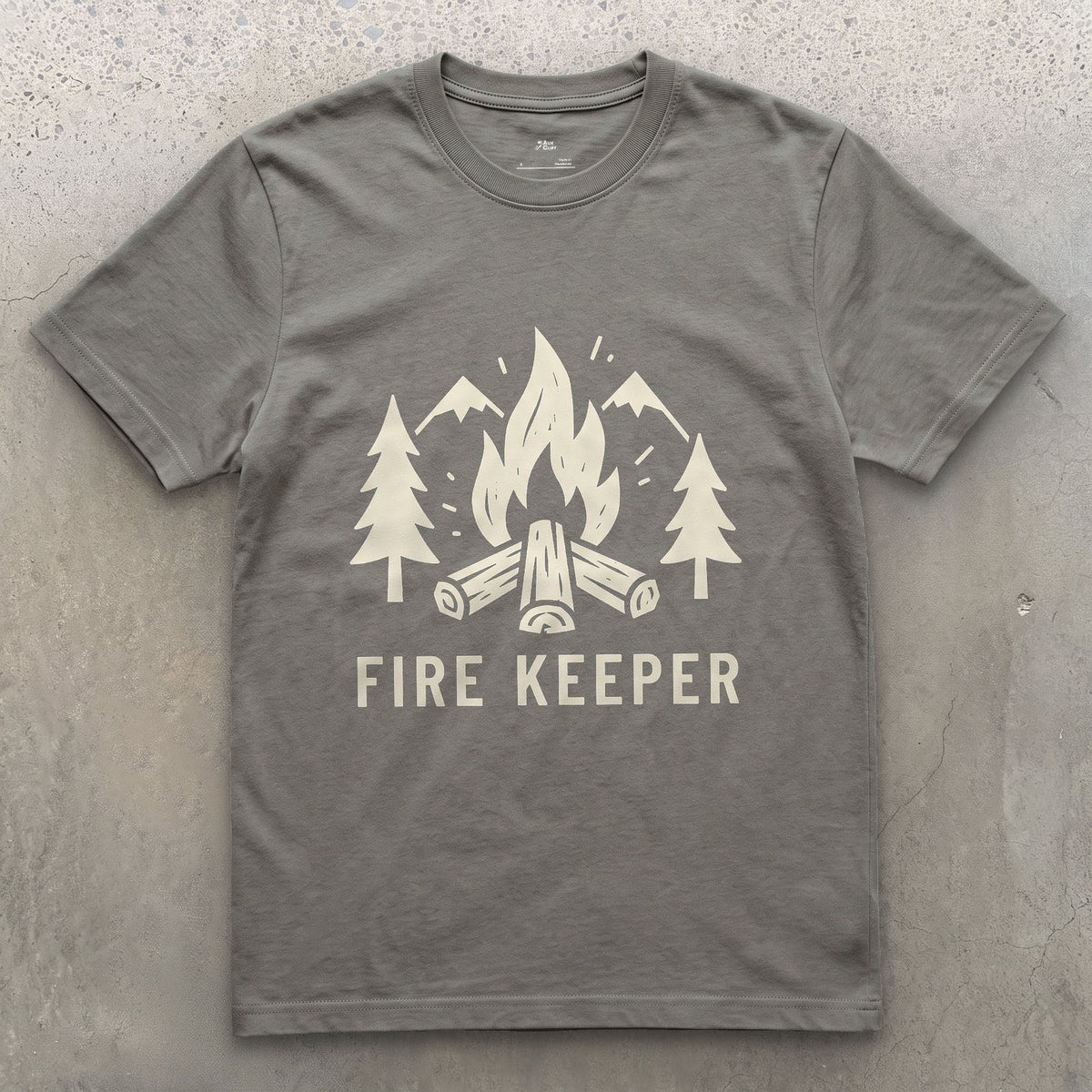 The Fire Keeper, Mountains and Firewood design on a Charcoal Gildan Softstyle t-shirt