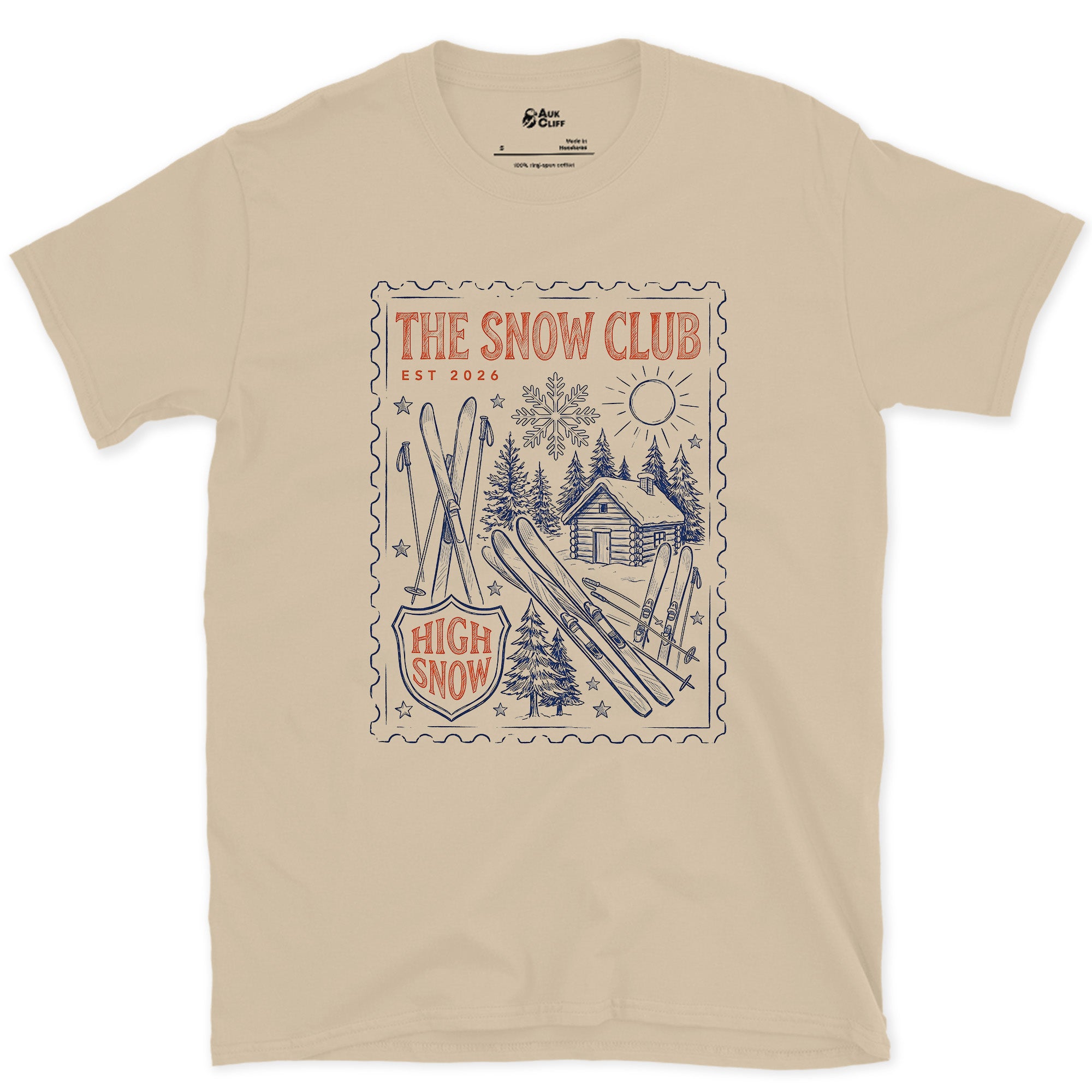 The Snow Club, Stamped With a Cabin and Skis design on a Sand Gildan Softstyle t-shirt