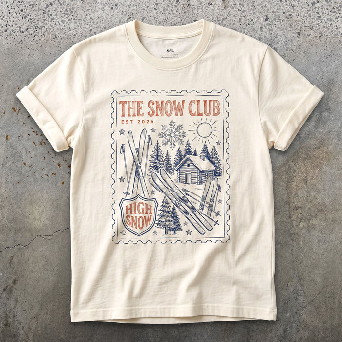 The Snow Club, Stamped With a Cabin and Skis design on a Natural Gildan Softstyle t-shirt