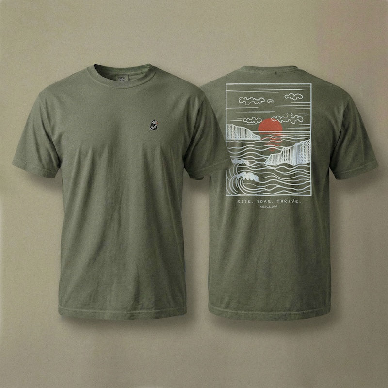 AukCliff Ocean Sunset Waves tee in Blue Jean, hand-drawn sunset and waves line art across the back