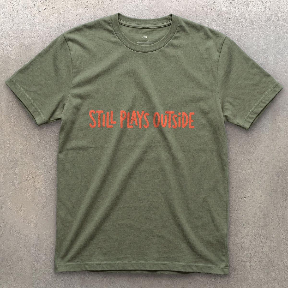 Coral, Still Plays Outside on the Mountain design on a Military Green Gildan Softstyle t-shirt