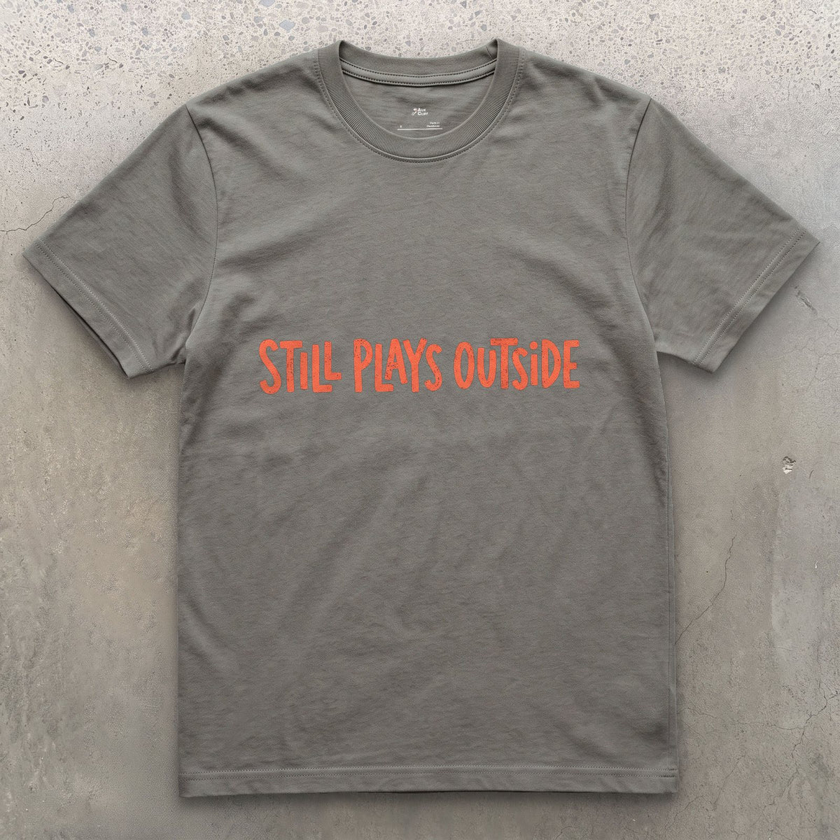 Coral, Still Plays Outside on the Mountain design on a Charcoal Gildan Softstyle t-shirt