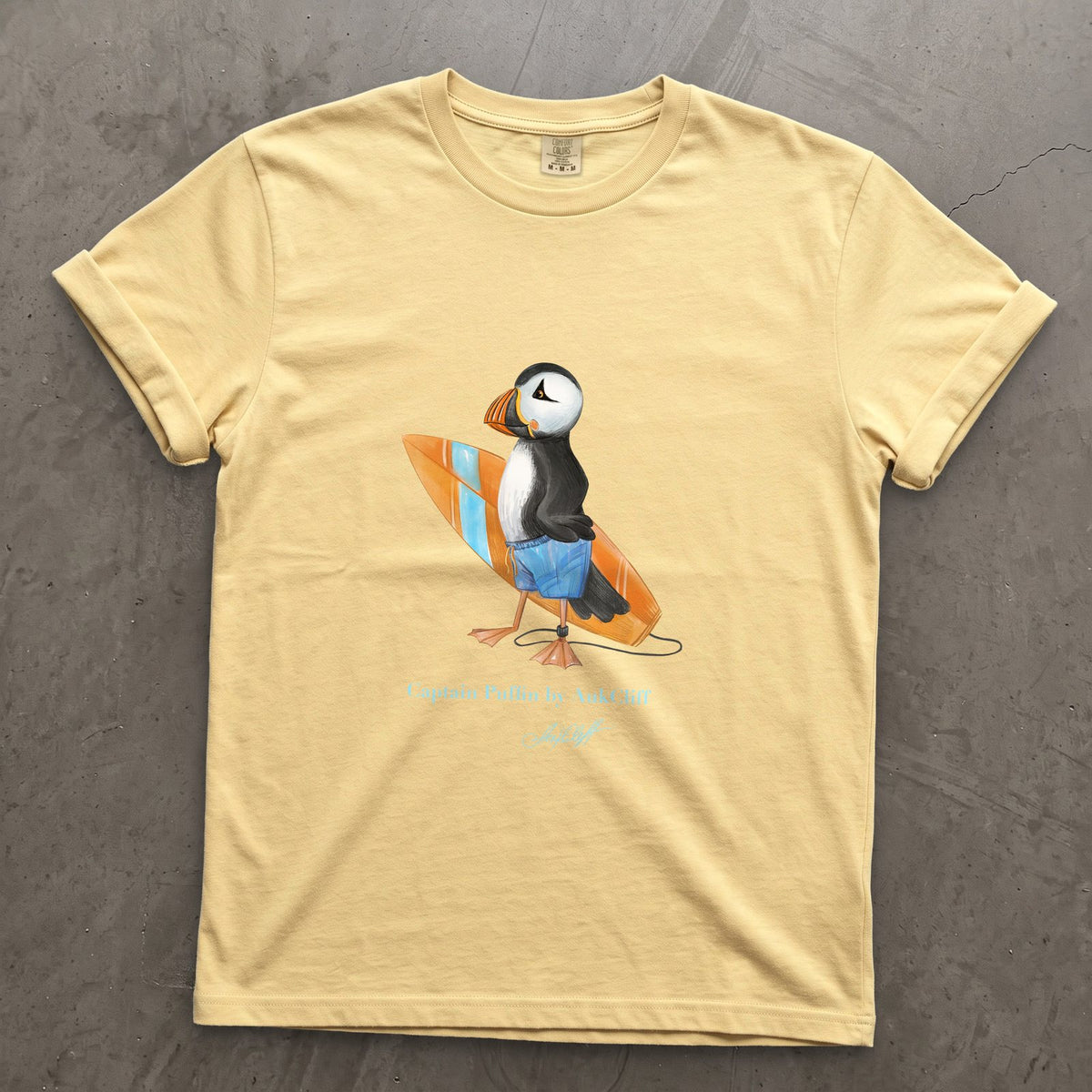 Captain Puffin Surfer on a Butter Comfort Colors t-shirt