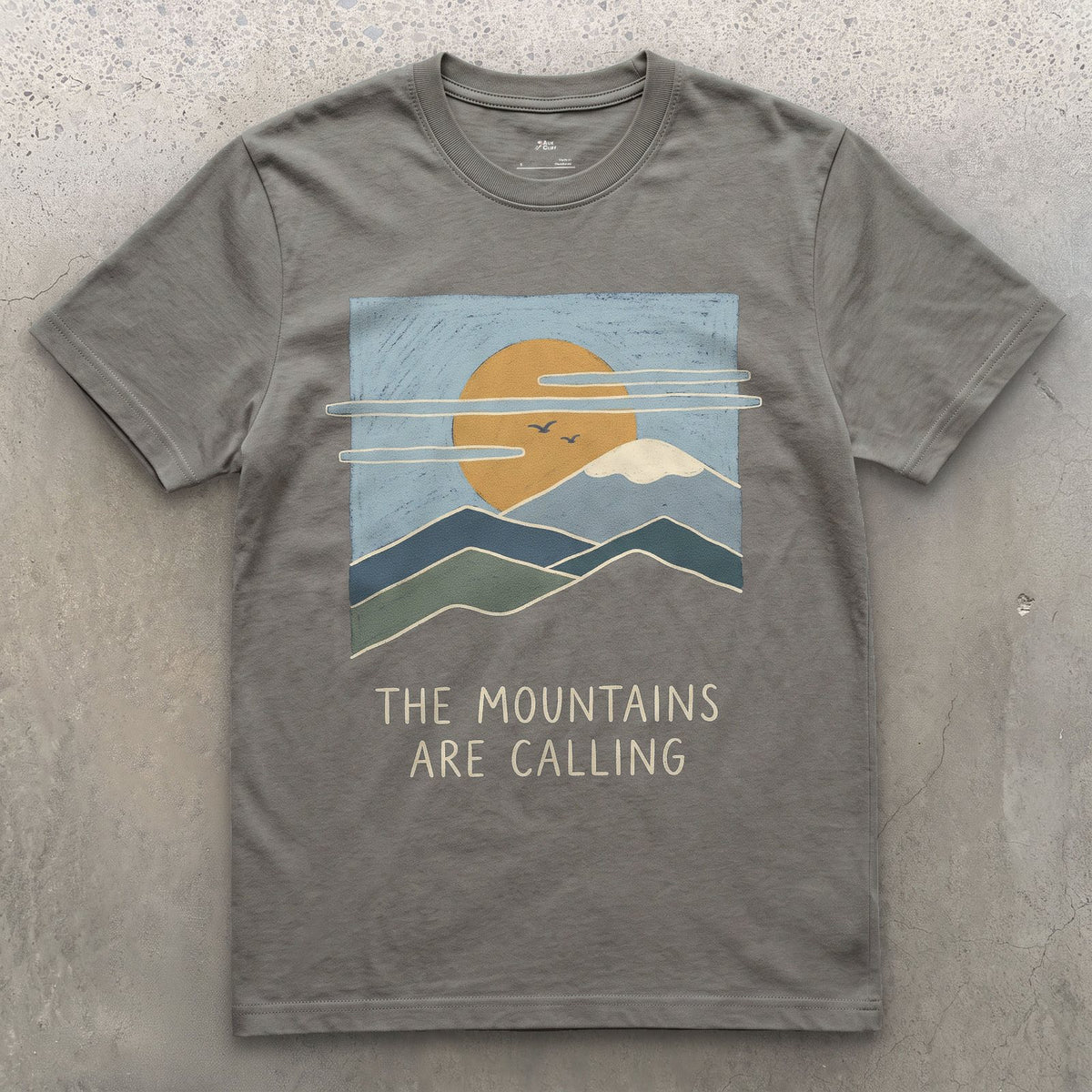 The Mountains Are Calling Over a Range at Sunset design on a Charcoal Gildan Softstyle t-shirt