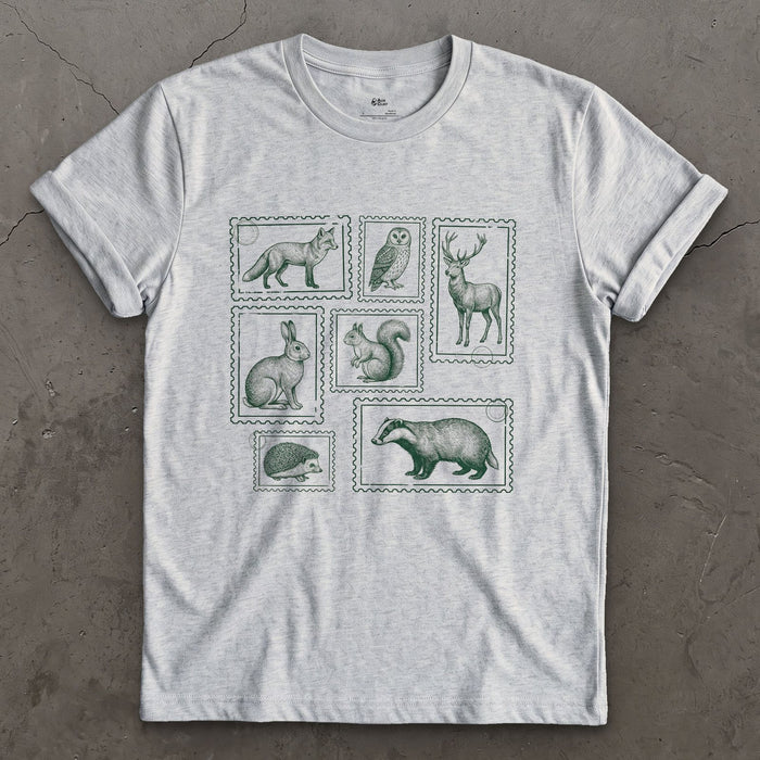 The Whole Woodland Framed Like Stamps design on a Sport Grey Gildan Softstyle t-shirt