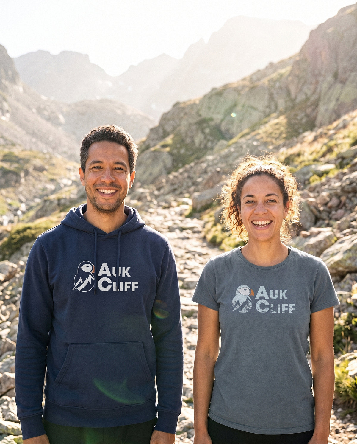 Two people wearing the AukCliff Collection on a mountain path
